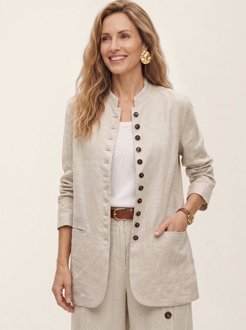 Woman wearing a beige collarless button-front jacket over a white top.