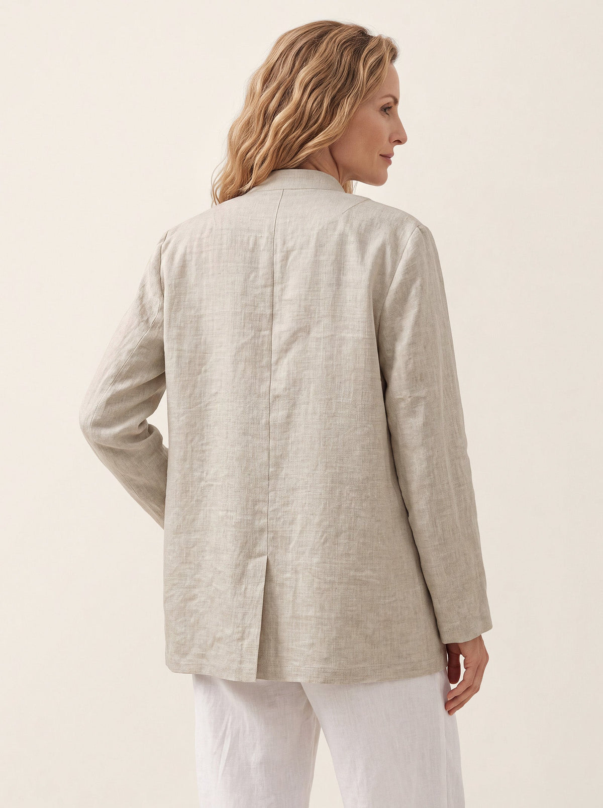 Rear view of a beige jacket showing its center seam and back vent.