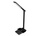 Black adjustable desk lamp with phone on charging base.