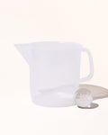 Translucent measuring pitcher with small scoop.
