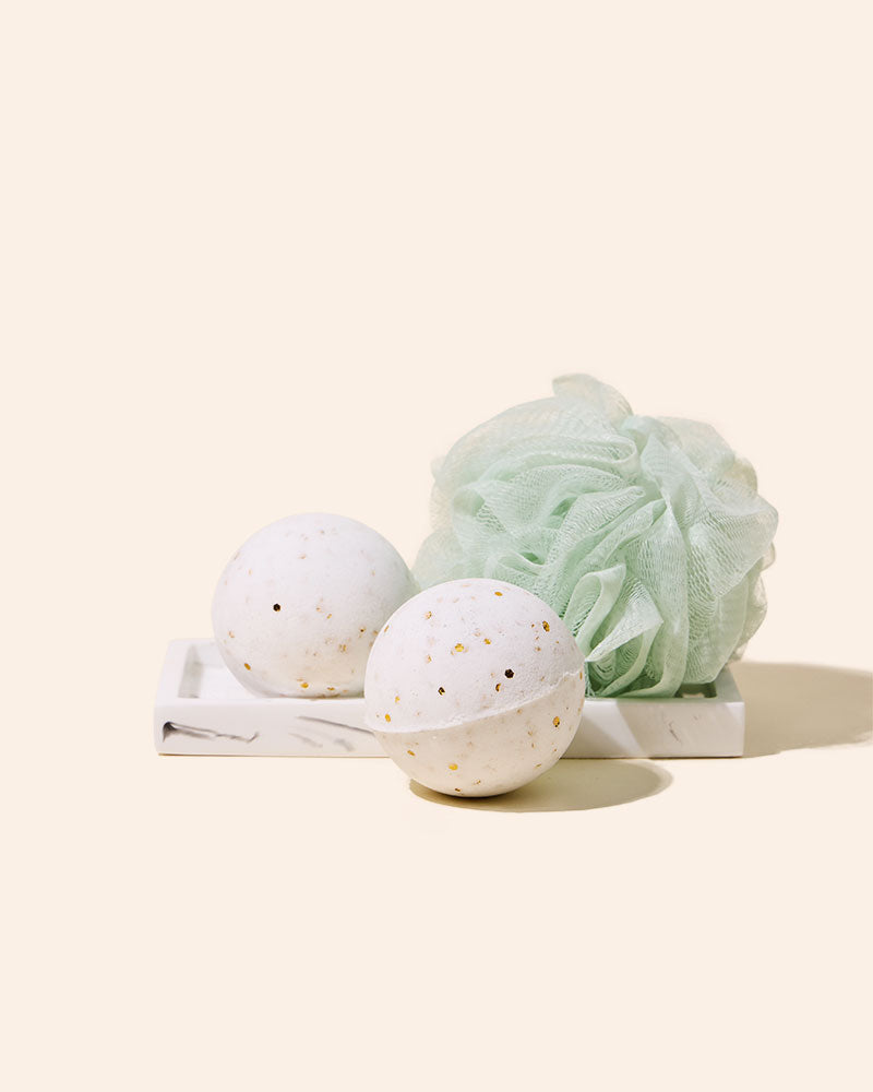 Speckled discs beside pale green bath puff.