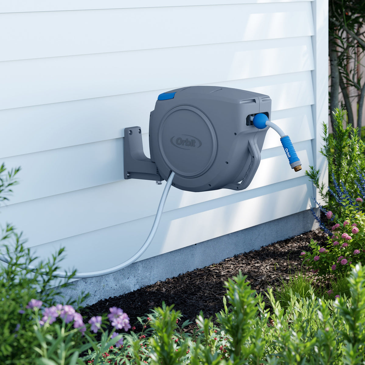 Hose reel mounted on white siding.