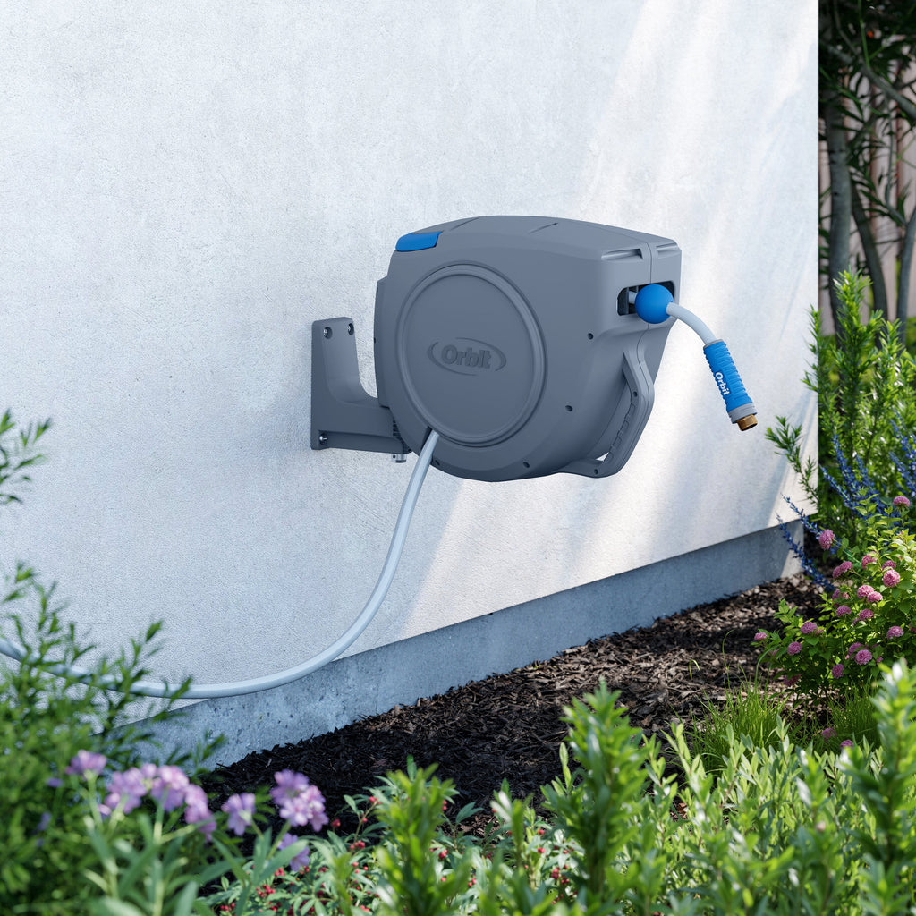 Hose reel mounted on white siding.
