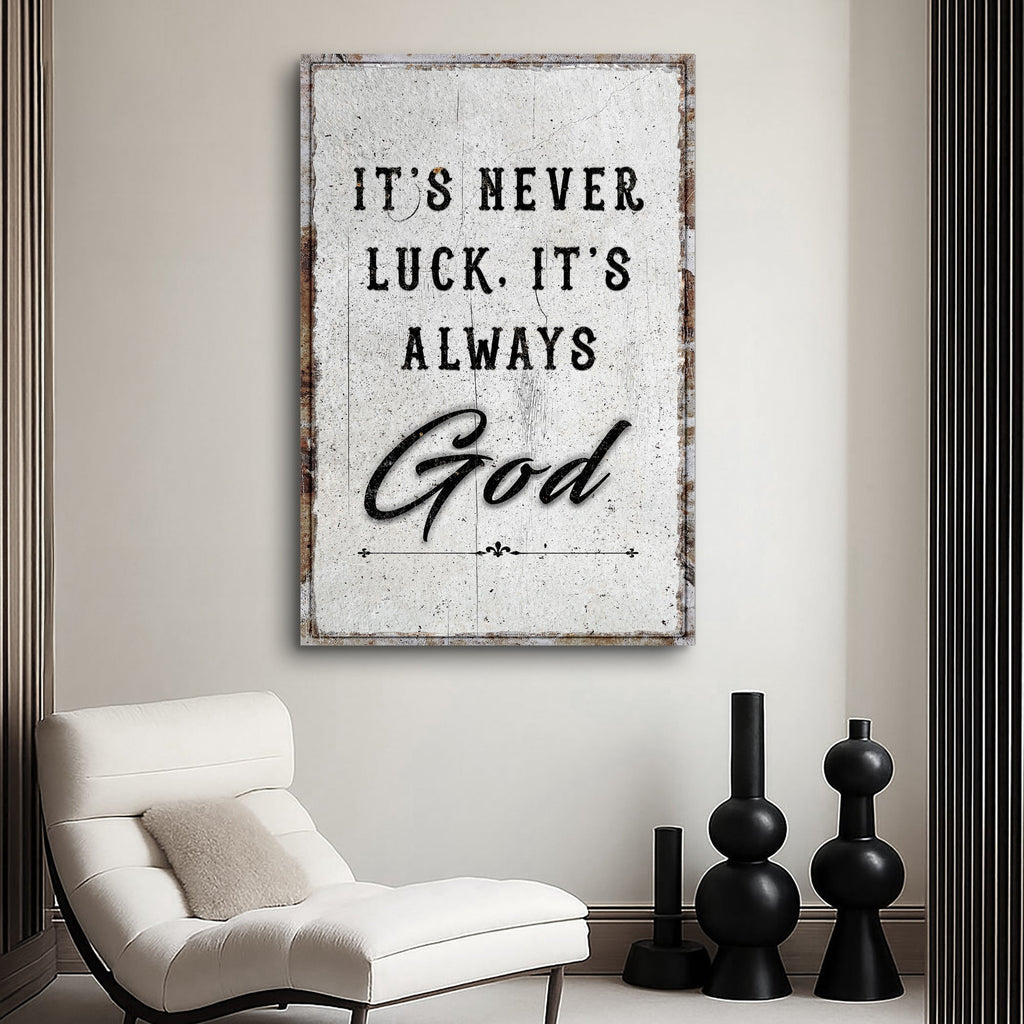 Distressed white It's never luck. It's always God canvas above a lounge chair.