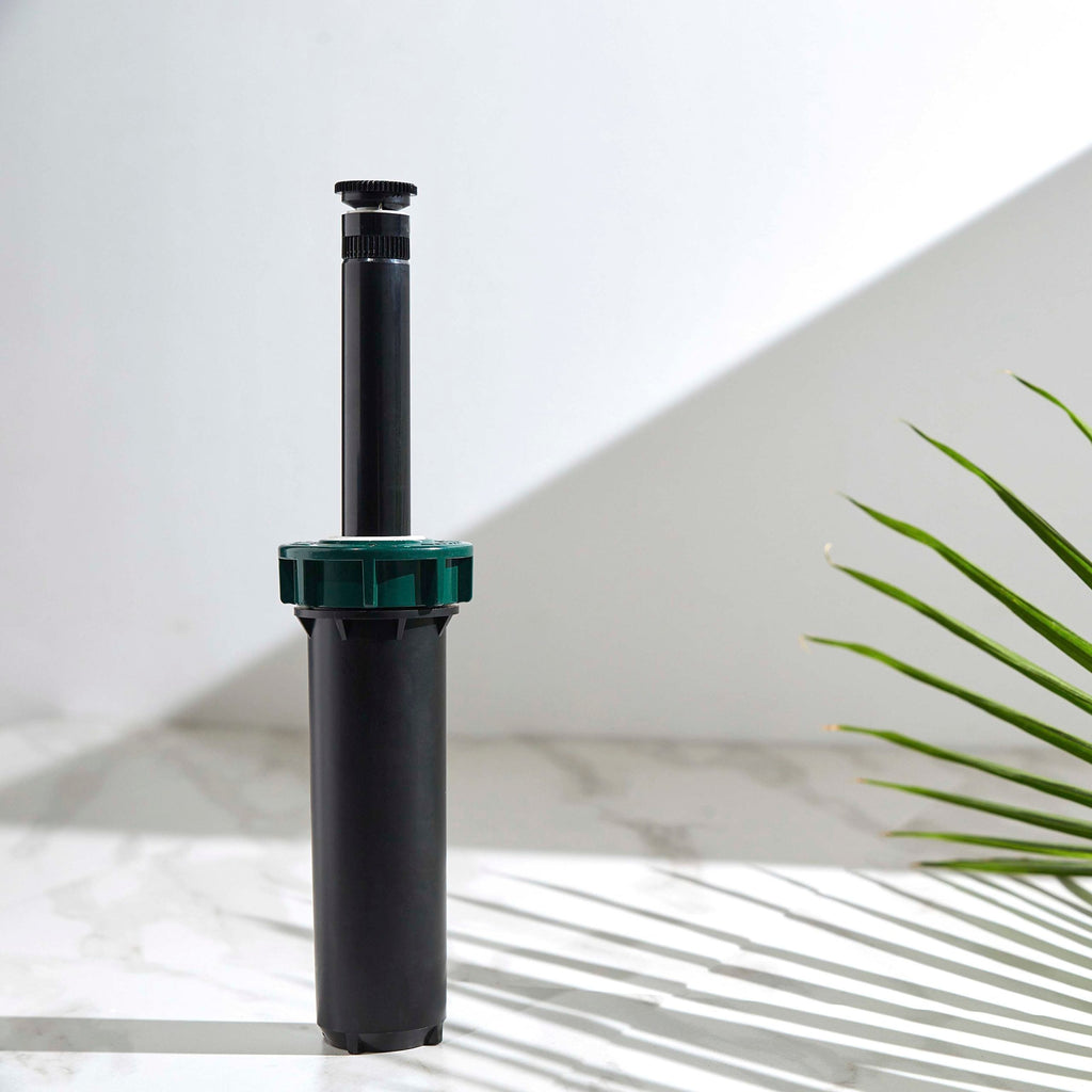 Black pop-up sprinkler standing on white surface.