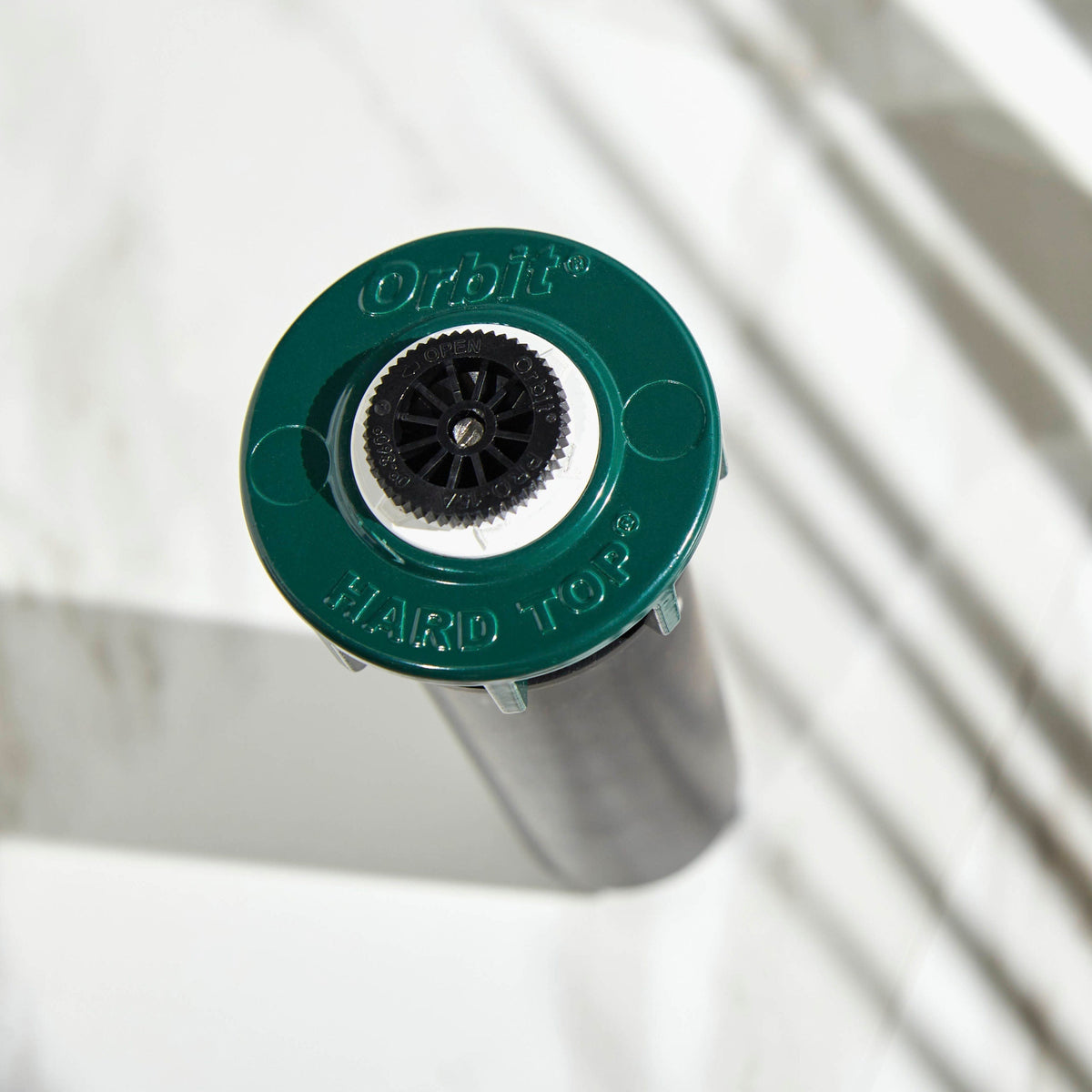 Close-up of sprinkler top and green collar.