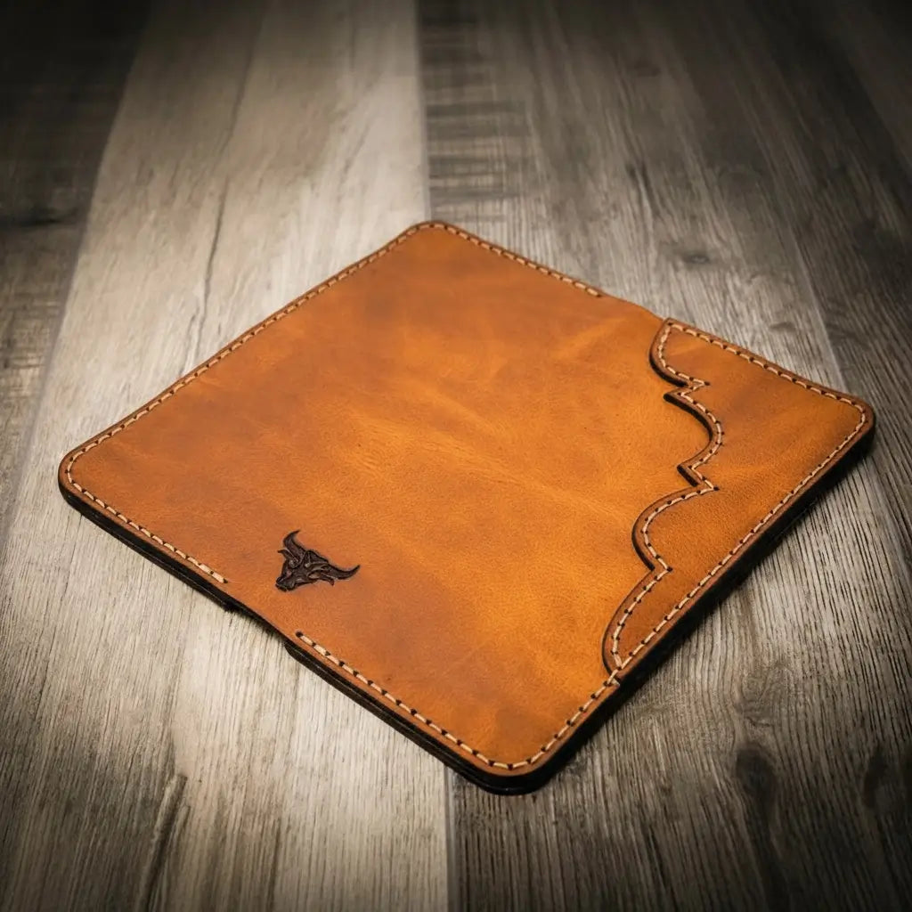 Closed tan wallet with wavy stitched edge and small logo.