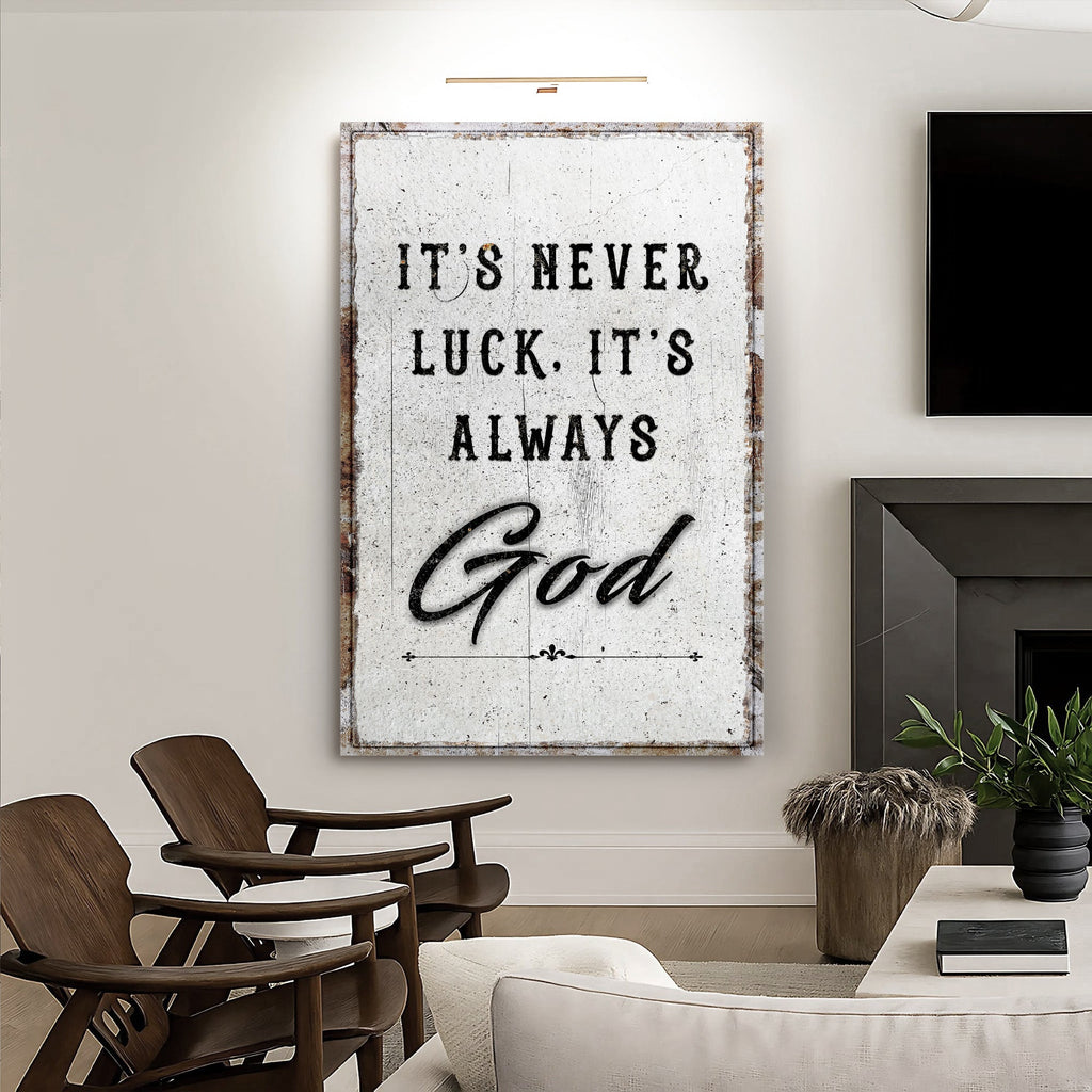 Distressed white It's never luck. It's always God canvas in a living room beside a fireplace.