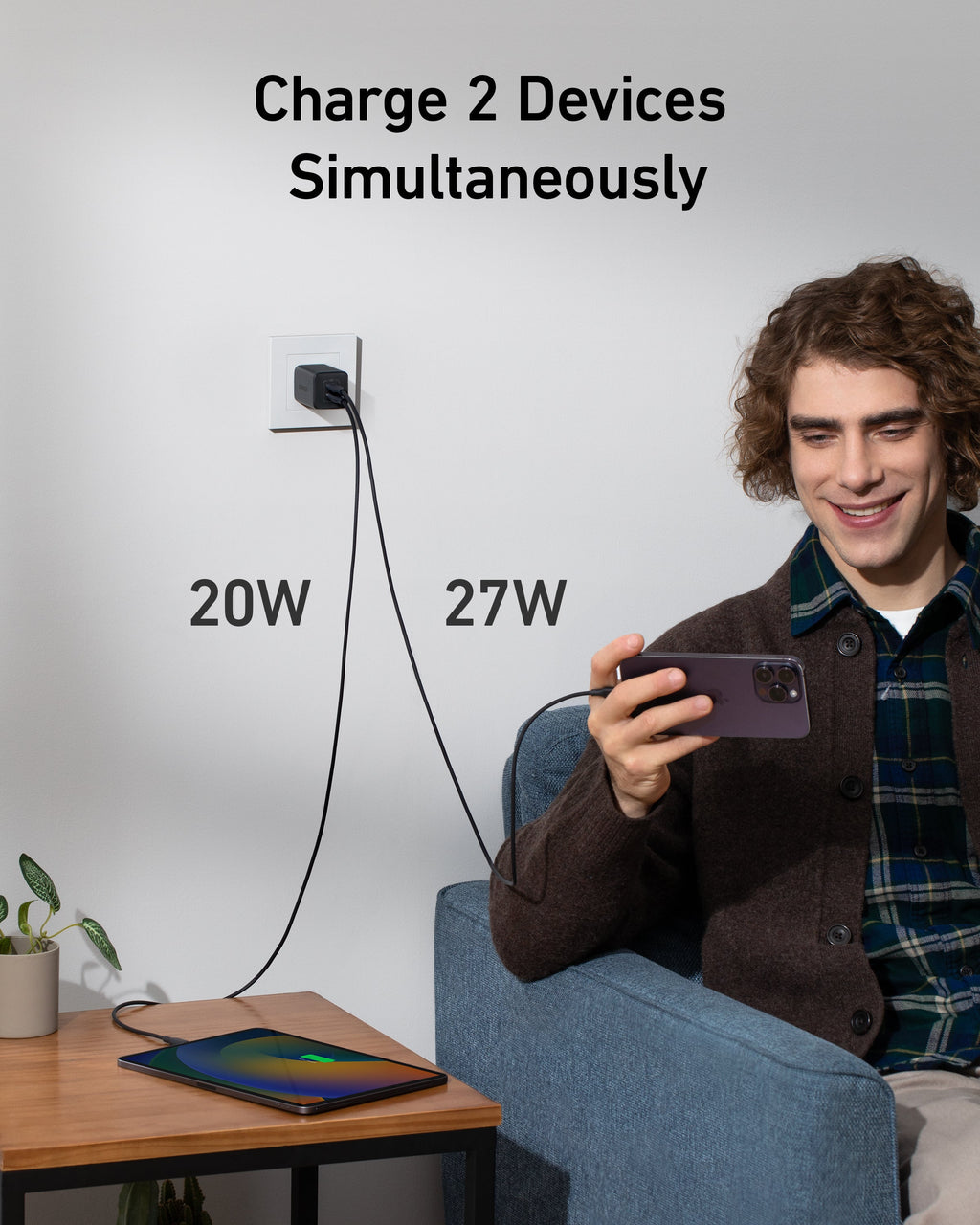 Black wall charger charging two devices.