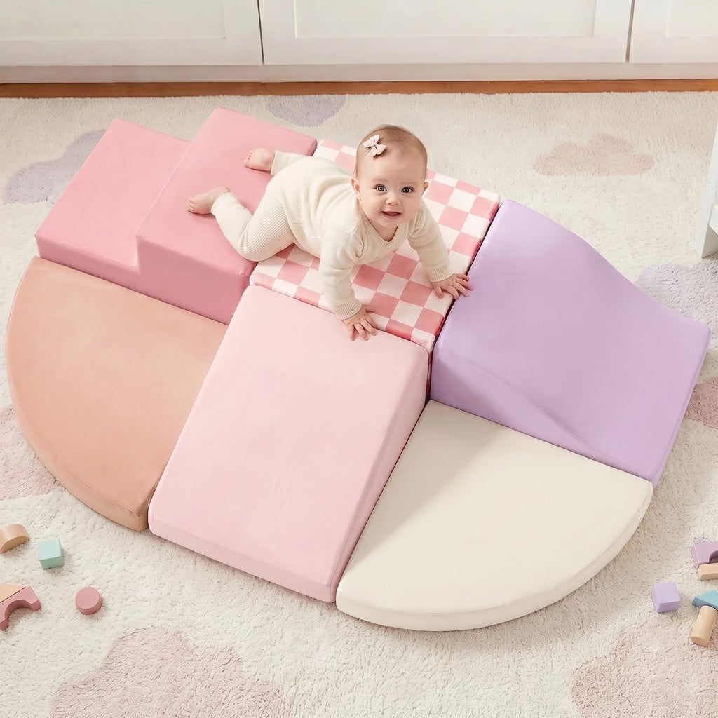 Toddler crawling over pink and purple foam blocks.
