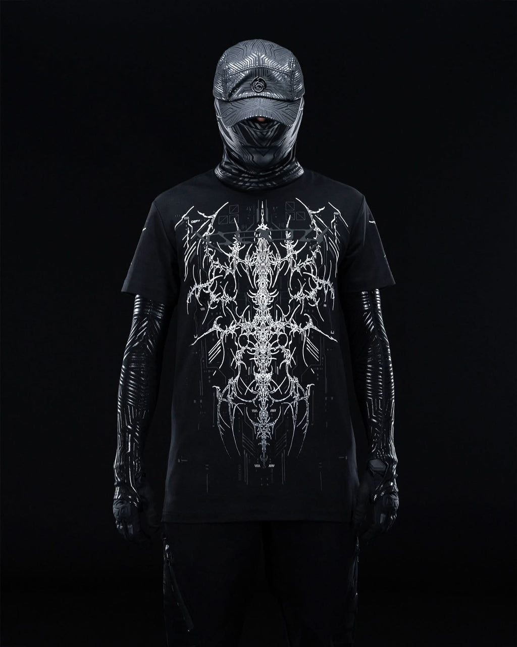 Front view of masked model wearing black T-shirt with fine gray ornamental artwork.