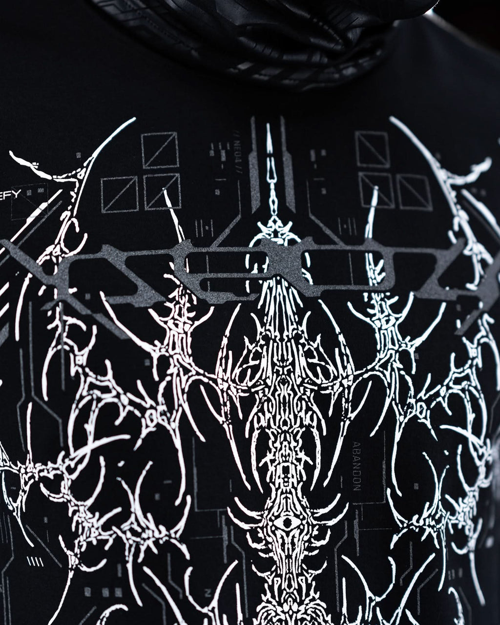 Close-up of upper front artwork on black T-shirt with gray ornamental graphics.