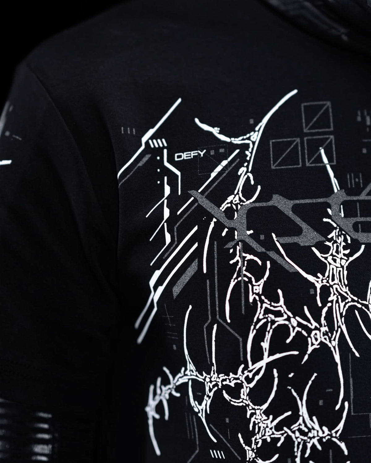 Close-up of shoulder artwork on black T-shirt with gray ornamental graphics.