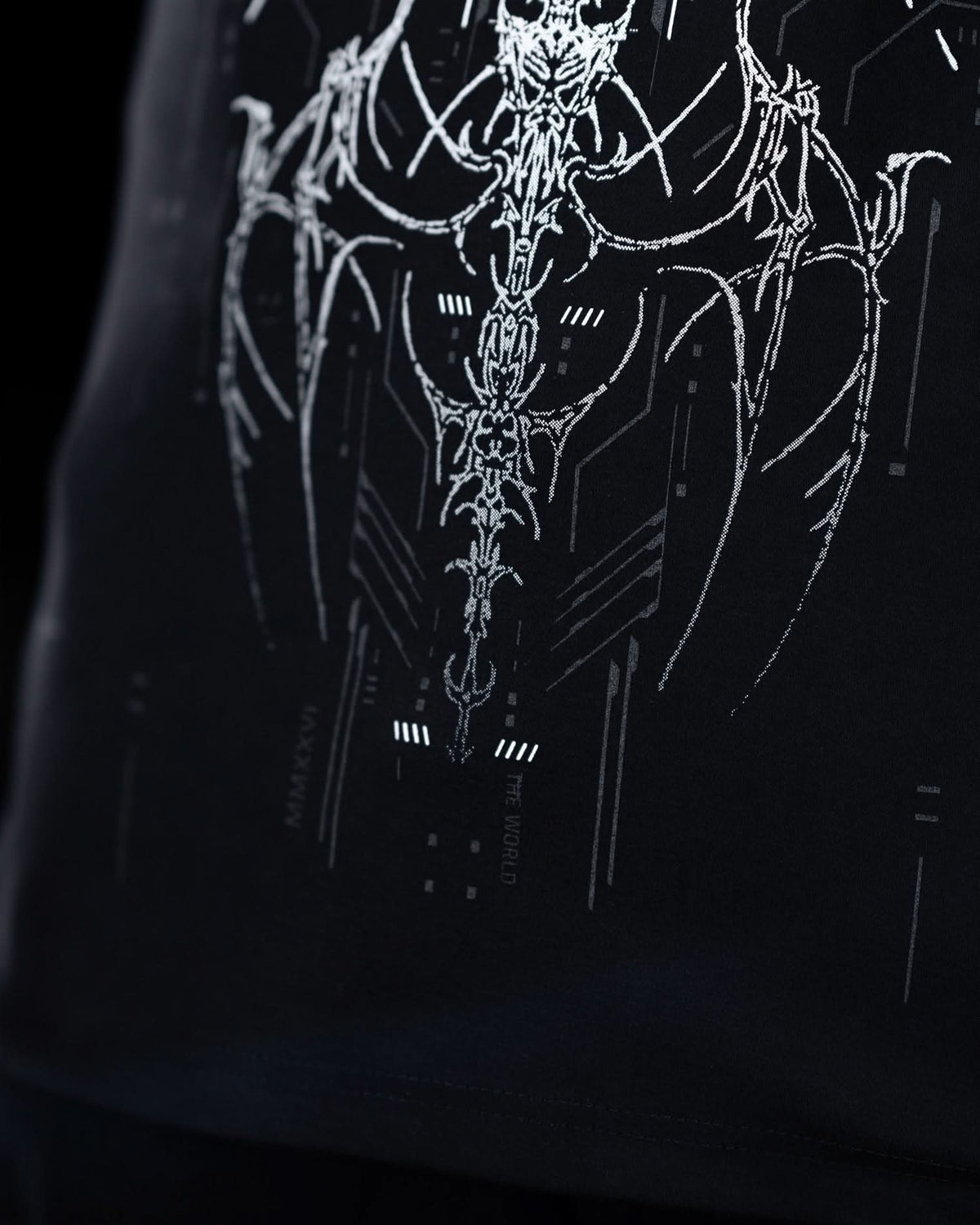 Close-up of lower front artwork on black T-shirt with gray ornamental graphics.