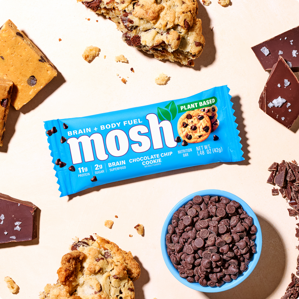 Blue MOSH chocolate chip cookie wrapper beside cookies and chocolate chips.