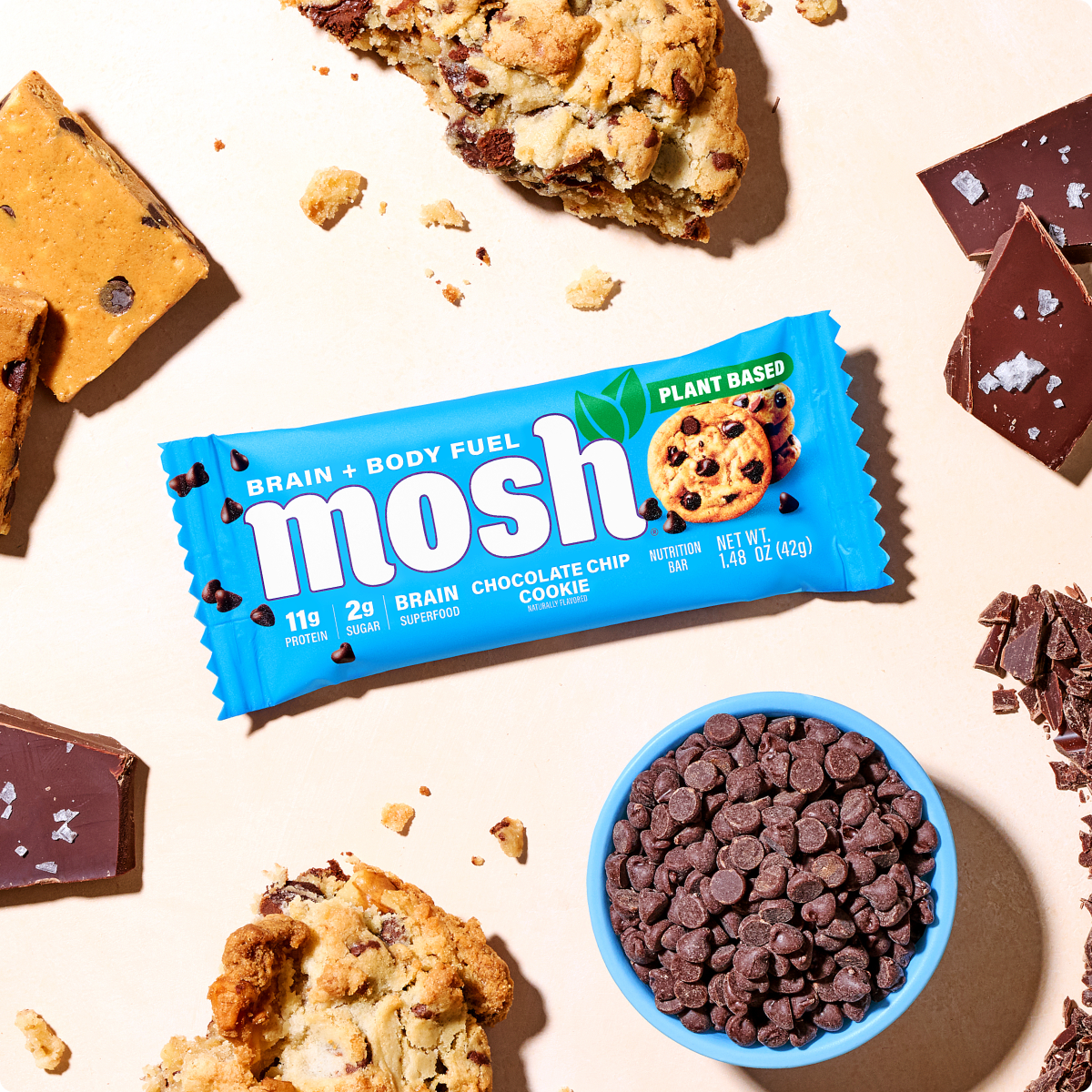 Blue MOSH chocolate chip cookie wrapper beside cookies and chocolate chips.