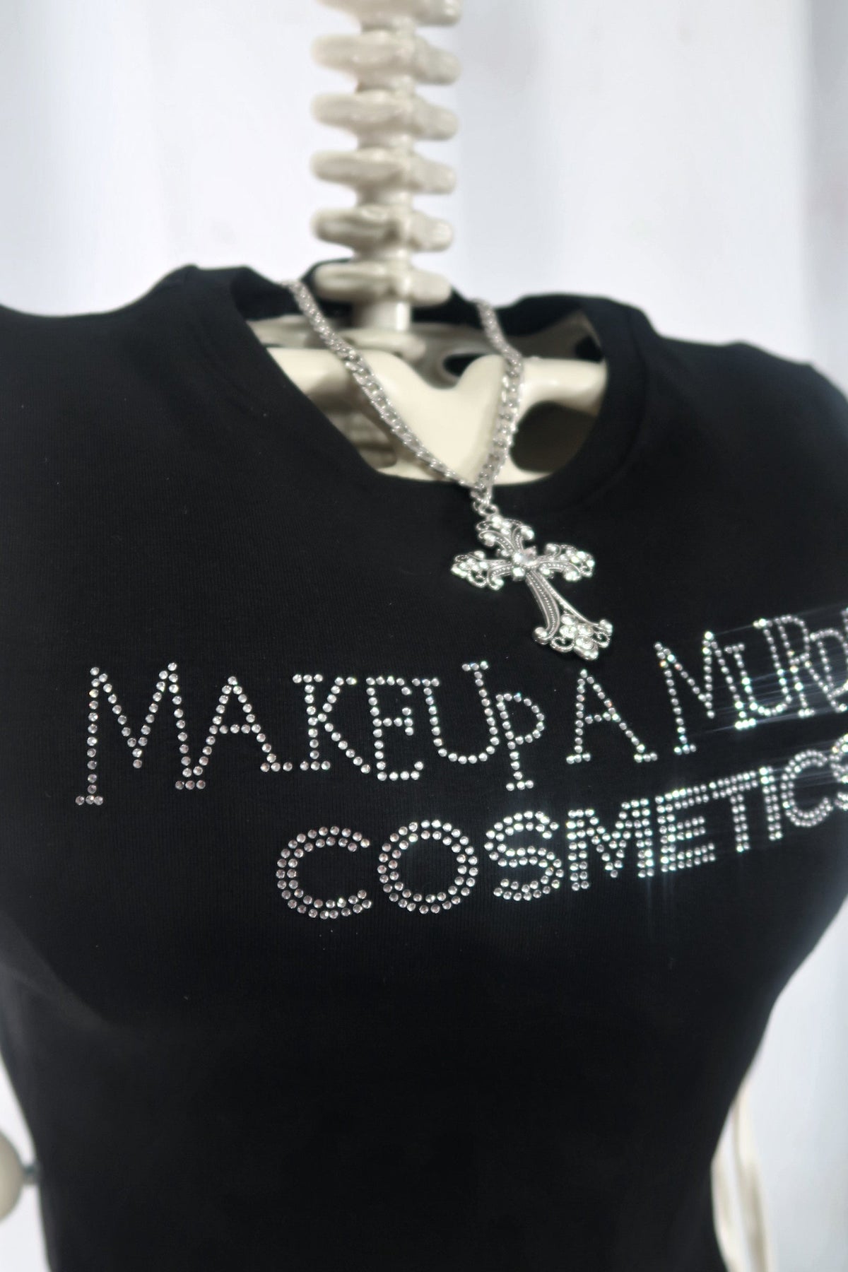 Angled view of black cropped cosmetics T-shirt.