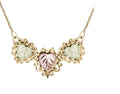 Gold-colored necklace with three pink and green leaf pendants.