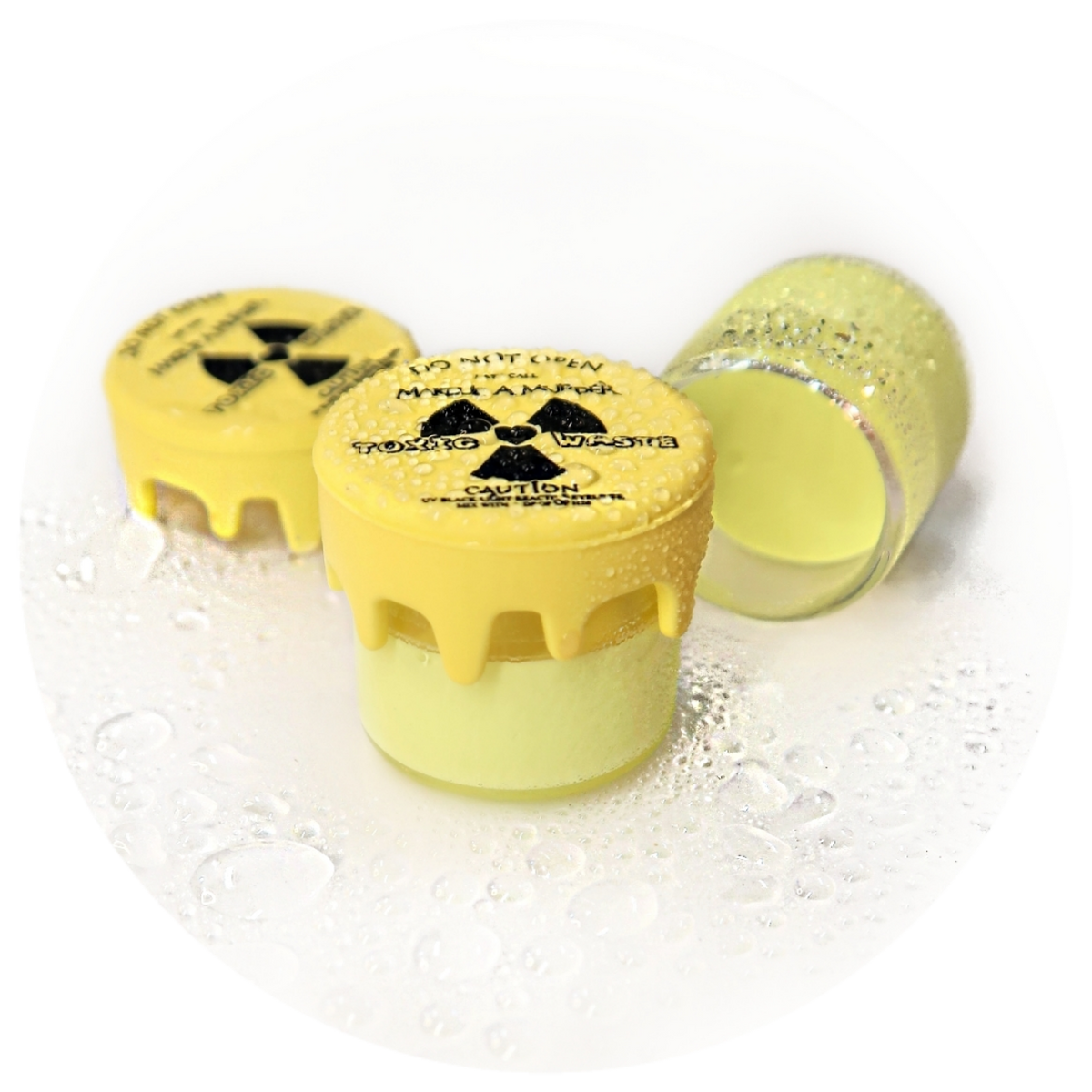 Pale yellow cosmetic pots with radiation-symbol lids.