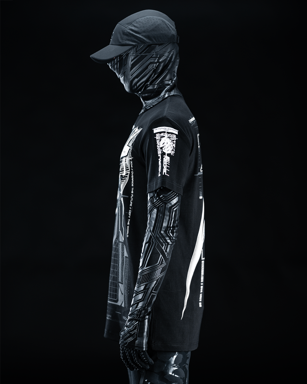 Side view of masked model wearing black T-shirt with gray technical artwork.