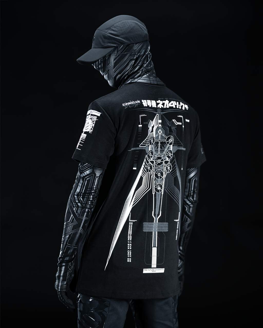 Angled rear view of masked model wearing black T-shirt with gray technical artwork.