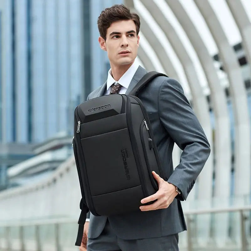 Man holding black backpack.