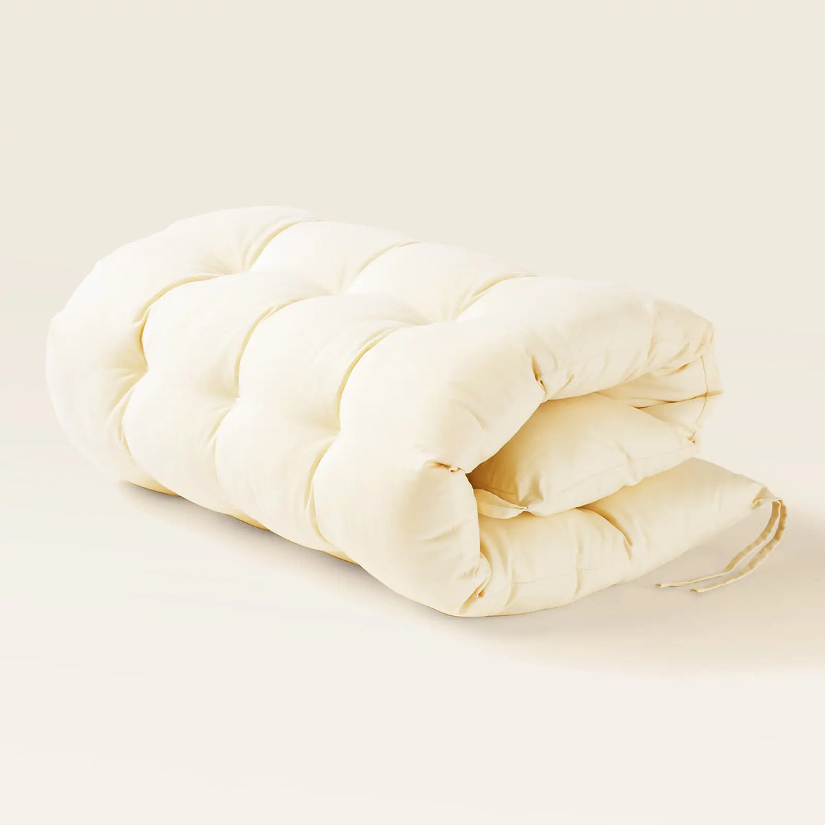 Folded cream tufted cushion.