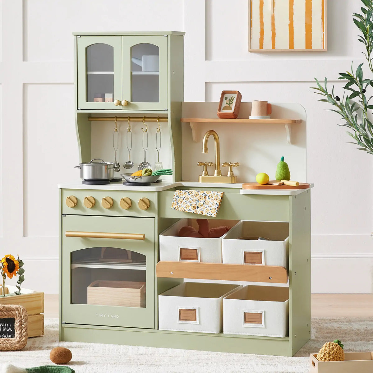 Green and wood toy kitchen with cookware and baskets.