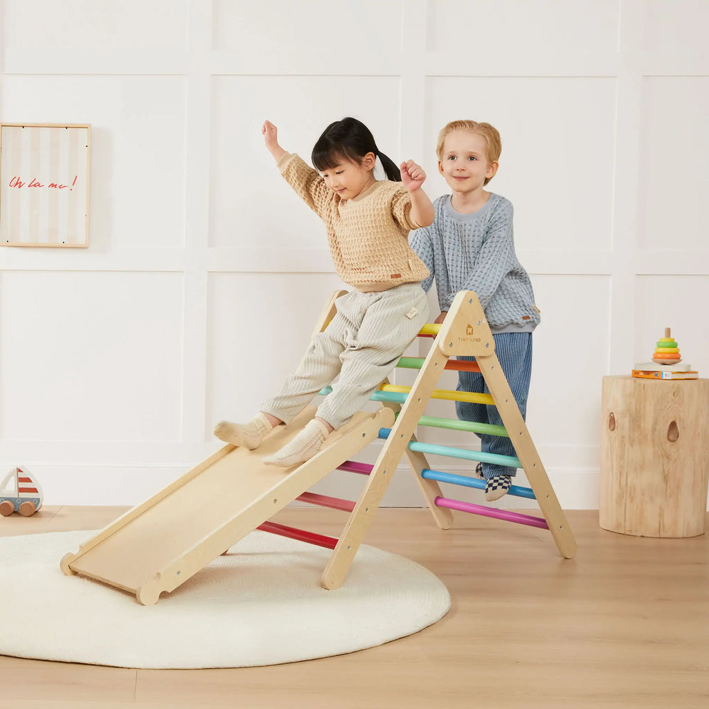 Children climbing a colorful wooden triangle and ramp.