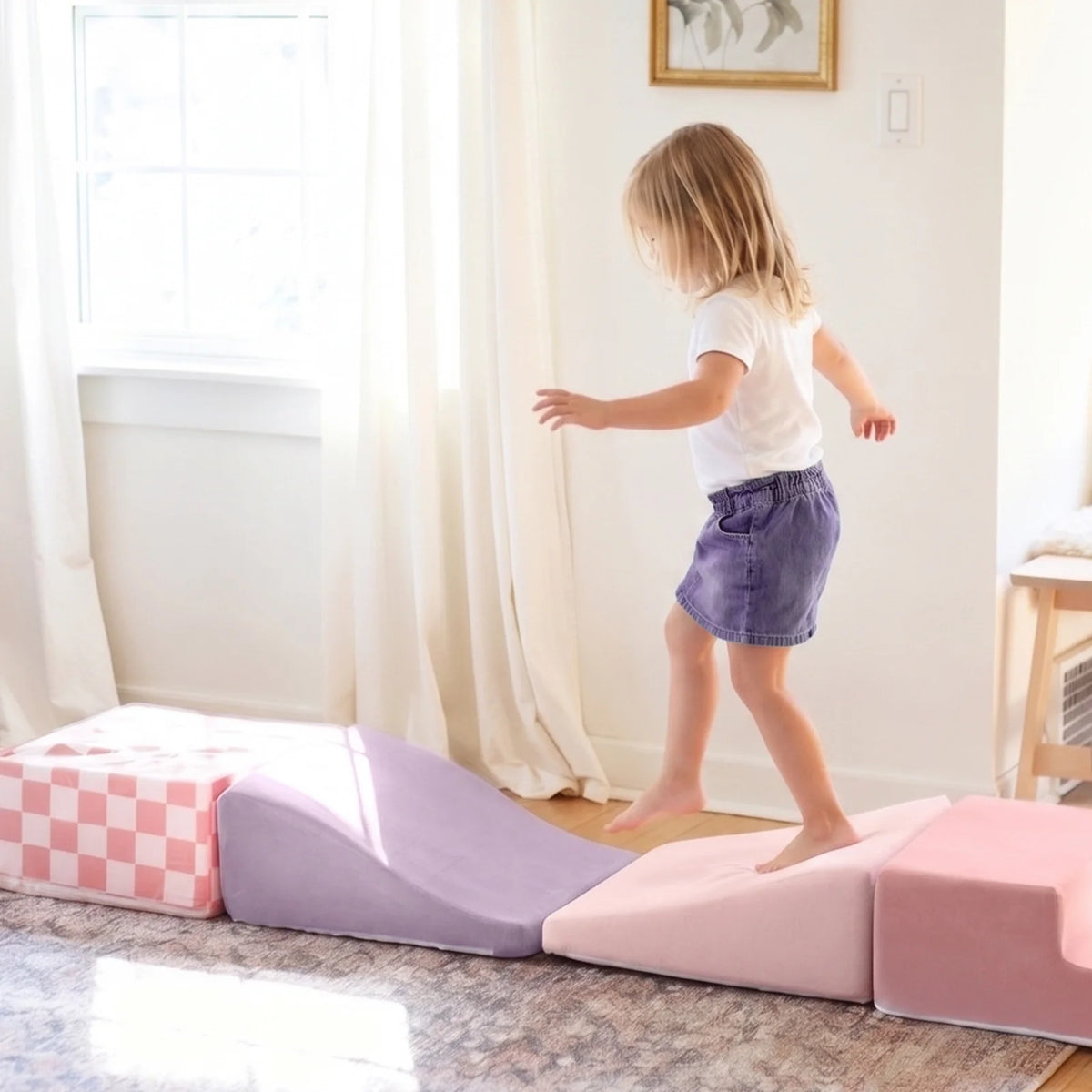 Child stepping across pink foam climbing blocks.