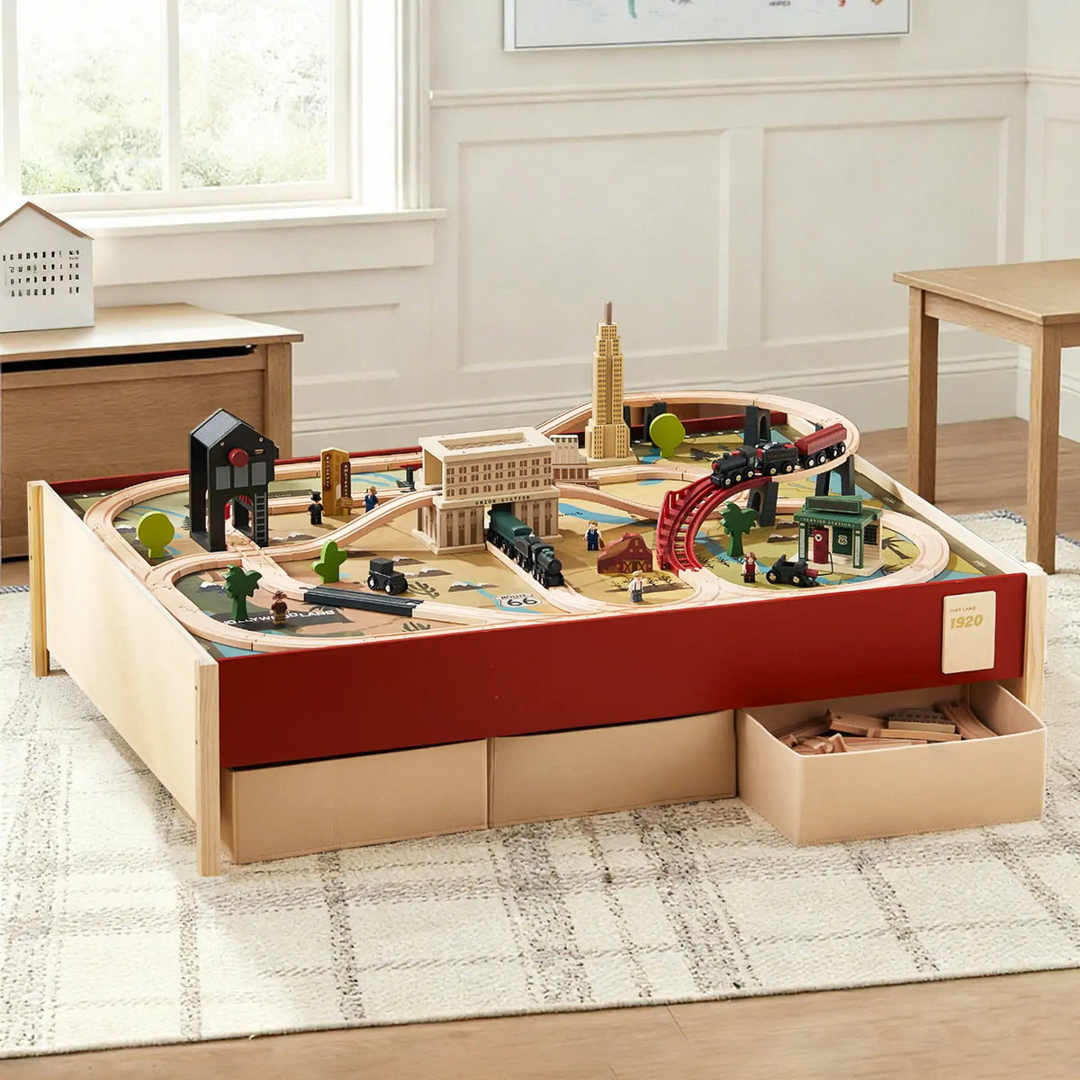 Wooden railway activity table with buildings and vehicles.