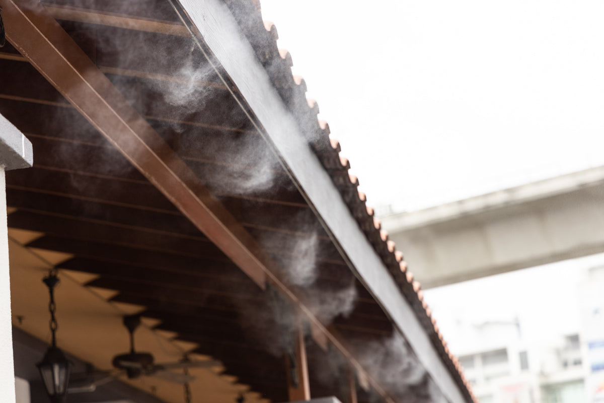 Misting tube installed along outdoor overhead beam.