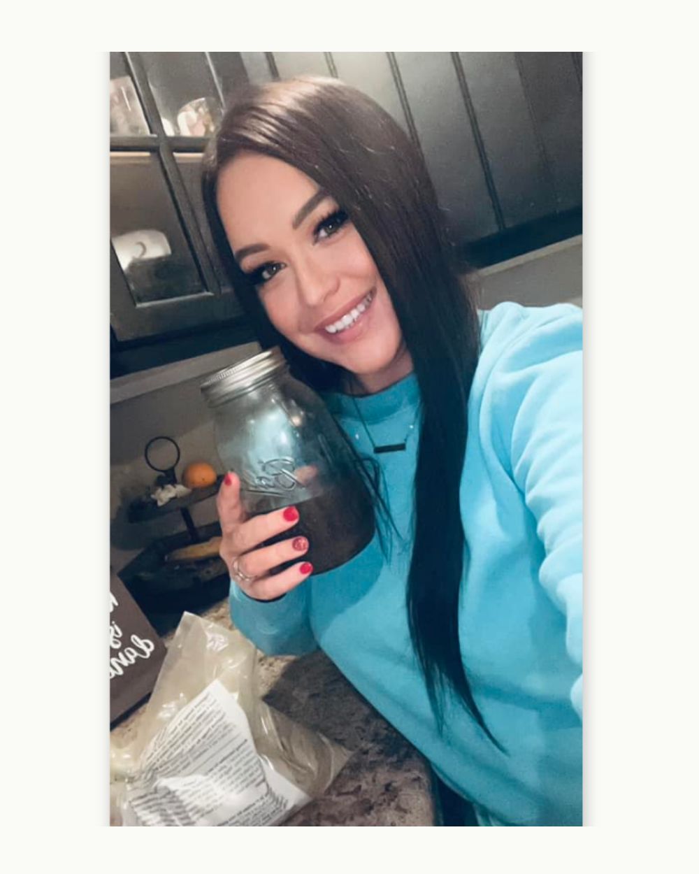 Woman holding cup and looking at phone.